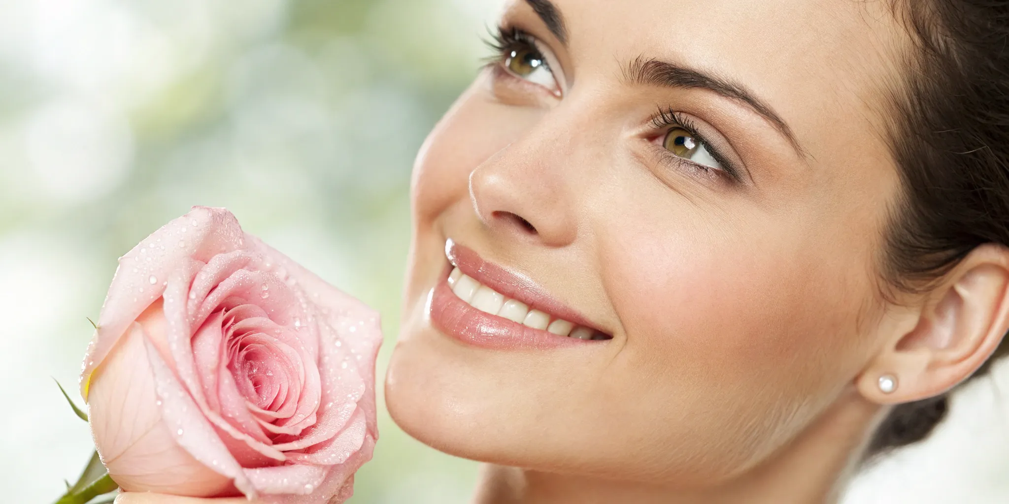Woman with youthful skin holding a rose.